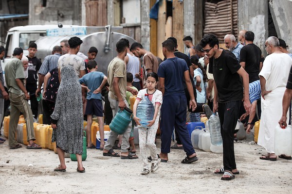 نازحون فلسطينيون يتجمعون للحصول على المياه من شاحنة توزيع في مخيم البريج وسط قطاع غزة، 8 يوليو/تموز 2026، مع تفاقم أزمة المياه إثر توقف عدد من محطات التحلية بسبب نقص الوقود. تصوير: معز صالحي
