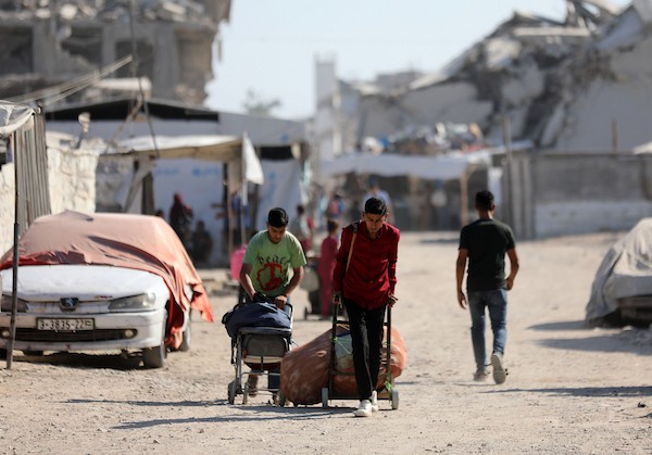 يحمل فلسطينيون نازحون أمتعتهم أثناء مغادرتهم خيامهم في حي الزيتون بمدينة غزة في 18 يوليو/تموز 2026. صورة: بلال أسامة