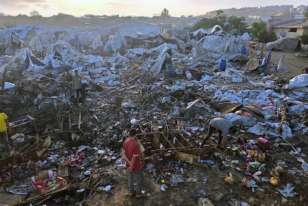 عائلات فلسطينية نازحة تتفقد الأضرار التي لحقت بخيامها وممتلكاتها بعد غارة إسرائيلية استهدفت مخيمًا للنازحين في منطقة المواصي بخان يونس، جنوب قطاع غزة، في 30 يونيو/حزيران 2026. تصوير: طارق محمد