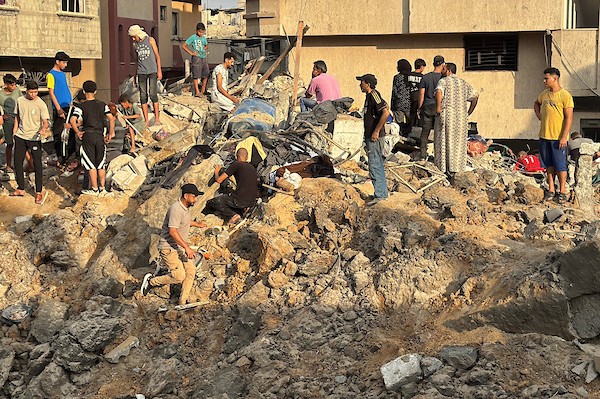 يتفقد فلسطينيون المباني المدمرة في موقع غارة جوية إسرائيلية على مخيم المغازي للاجئين، وسط قطاع غزة، يوم الجمعة 24 يوليو/تموز 2026. تصوير: أحمد إبراهيم