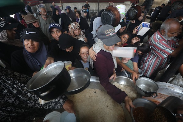فلسطينيون نازحون يتجمعون للحصول على وجبات محدودة من مطبخ خيري يُعد الوحيد المتبقي في مخيم النصيرات وسط قطاع غزة، في 23 يوليو/تموز 2026. تصوير: حسن الجدي