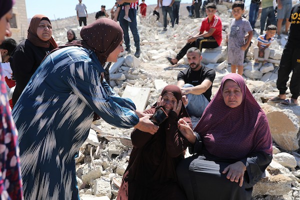 يجلس فلسطينيون على أنقاض منزل هدمته القوات الإسرائيلية في بلدة بيت عوا، جنوب الخليل، بالضفة الغربية ، في 20 يوليو/تموز 2026.صورة: مأمون وزواز