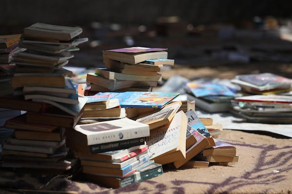 يعرض بائع الكتب محمد رمضان سعد ( 56 عامًا) مجموعة من الكتب في كشك على جانب الطريق في دير البلح، وسط قطاع غزة، في 2 يوليو/تموز 2026. تصوير: حسن الجدي