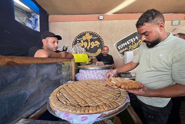فلسطينيون يشترون الحلوى من متجر محلي عقب إعلان نتائج امتحانات التوجيهي في خان يونس، جنوب قطاع غزة، في 24 يوليو/تموز 2026. صورة: طارق محمد