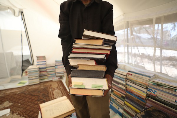 يعرض بائع الكتب محمد رمضان سعد ( 56 عامًا) مجموعة من الكتب في كشك على جانب الطريق في دير البلح، وسط قطاع غزة، في 2 يوليو/تموز 2026. تصوير: حسن الجدي