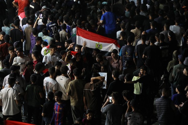 فلسطينيون يتابعون عبر شاشة عرض عامة في مدينة غزة مباراة مصر وأستراليا ضمن دور الـ32 من كأس العالم، في 3 يوليو/تموز 2026، وسط التحديات الإنسانية المستمرة في القطاع.  صورة: بلال أسامة