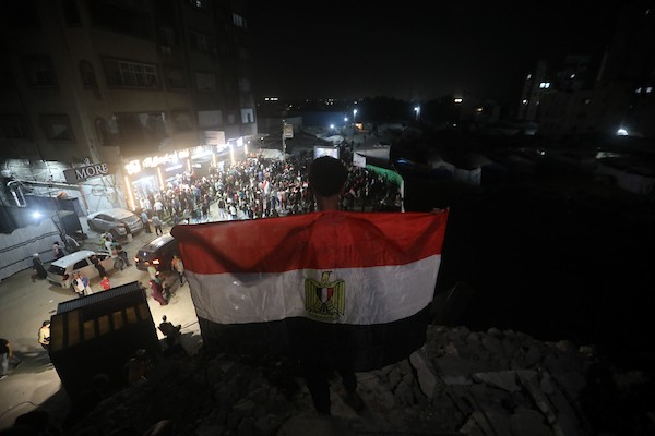 فلسطينيون يتابعون عبر شاشة عرض عامة في مدينة غزة مباراة مصر وأستراليا ضمن دور الـ32 من كأس العالم، في 3 يوليو/تموز 2026، وسط التحديات الإنسانية المستمرة في القطاع.  صورة: بلال أسامة