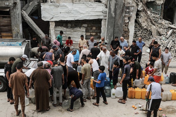 نازحون فلسطينيون يتجمعون للحصول على المياه من شاحنة توزيع في مخيم البريج وسط قطاع غزة، 8 يوليو/تموز 2026، مع تفاقم أزمة المياه إثر توقف عدد من محطات التحلية بسبب نقص الوقود. تصوير: معز صالحي