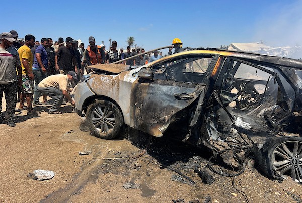 تجمّع فلسطينيون في موقع غارة إسرائيلية استهدفت مركبة مدنية في منطقة الزهراء، شمال مخيم النصيرات للاجئين وسط قطاع غزة، في 21 يوليو/تموز 2026. صورة: حسن الجدي
