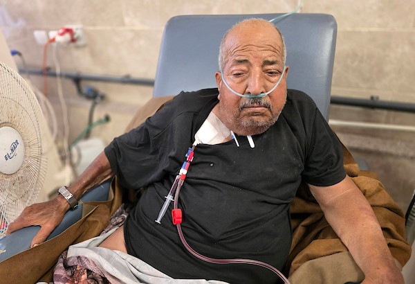 فتحي حجي، 77 عاماً، مريض كلى ويستخدم أسطوانة أكسجين، يجلس على كرسي متحرك أثناء نقله على عربة تجرها الحيوانات من منطقة بئر 19 في المواصي بمدينة خان يونس، جنوب قطاع غزة، في 22 يوليو/تموز 2026.  تصوير: طارق محمد