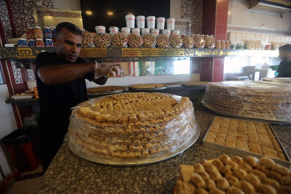 عمال يُعدّون تشكيلة من الحلويات داخل محل في مدينة غزة، في 23 يوليو/تموز 2026، عشية إعلان نتائج امتحان «التوجيهي». تصوير: بلال أسامة