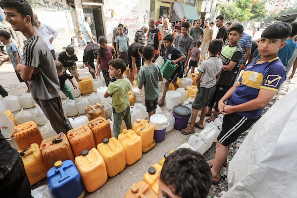 نازحون فلسطينيون يتجمعون للحصول على المياه من شاحنة توزيع في مخيم البريج وسط قطاع غزة، 8 يوليو/تموز 2026، مع تفاقم أزمة المياه إثر توقف عدد من محطات التحلية بسبب نقص الوقود. تصوير: معز صالحي