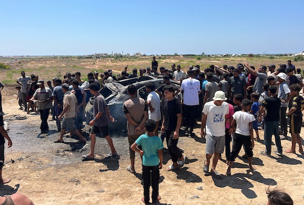 تجمّع فلسطينيون في موقع غارة إسرائيلية استهدفت مركبة مدنية في منطقة الزهراء، شمال مخيم النصيرات للاجئين وسط قطاع غزة، في 21 يوليو/تموز 2026. صورة: حسن الجدي