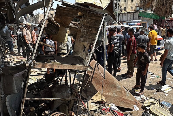 تجمّع فلسطينيون في موقع غارة جوية إسرائيلية قرب مدخل مستشفى شهداء الأقصى في دير البلح، وسط قطاع غزة، بينما كانت فرق الإسعاف تُجلي الجرحى من الموقع، في 25 يوليو/تموز 2026.صورة: أحمد إبراهيم