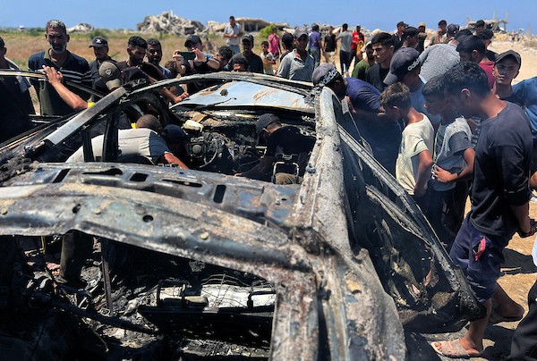 تجمّع فلسطينيون في موقع غارة إسرائيلية استهدفت مركبة مدنية في منطقة الزهراء، شمال مخيم النصيرات للاجئين وسط قطاع غزة، في 21 يوليو/تموز 2026. صورة: حسن الجدي