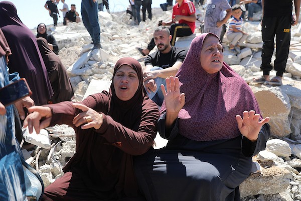 يجلس فلسطينيون على أنقاض منزل هدمته القوات الإسرائيلية في بلدة بيت عوا، جنوب الخليل، بالضفة الغربية ، في 20 يوليو/تموز 2026.صورة: مأمون وزواز