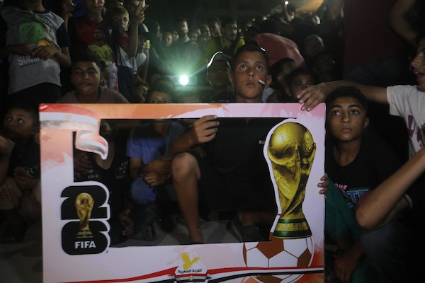 فلسطينيون يتابعون عبر شاشة عرض عامة في مدينة غزة مباراة مصر وأستراليا ضمن دور الـ32 من كأس العالم، في 3 يوليو/تموز 2026، وسط التحديات الإنسانية المستمرة في القطاع.  صورة: بلال أسامة