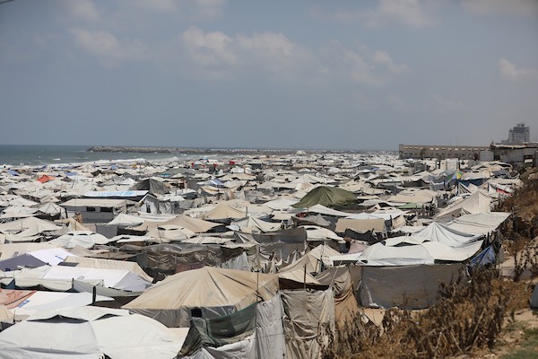 فلسطينيون نازحون يعيشون داخل خيام مؤقتة مكتظة على طول شاطئ مدينة غزة، في 9 يوليو/تموز 2026، وسط حرارة صيفية مرتفعة ونقص في المياه النظيفة والخدمات الأساسية، بعد فرارهم من مناطق متفرقة من القطاع. (تصوير: بلال أسامة)
