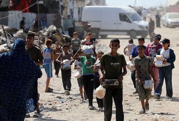 في الثاني من يوليو/تموز 2026، تجمع فلسطينيون نازحون، بينهم نساء وأطفال، لتلقي وجبات طعام من مركز توزيع خيري شرق مدينة غزة. (صورة: بلال أسامة)