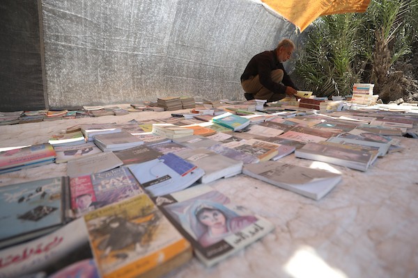 يعرض بائع الكتب محمد رمضان سعد ( 56 عامًا) مجموعة من الكتب في كشك على جانب الطريق في دير البلح، وسط قطاع غزة، في 2 يوليو/تموز 2026. تصوير: حسن الجدي