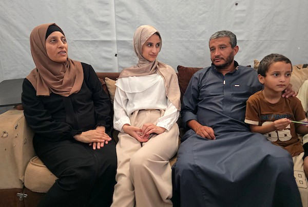 الطالبة نور عودة تحتفل مع عائلتها داخل منزل متضرر في خان يونس، بعد حصولها على معدل 99.7% في المسار العلمي وحلولها أولى على قطاع غزة وثانية على مستوى فلسطين في امتحانات التوجيهي، 24 تموز/ يوليو 2026. تصوير: طارق محمد
