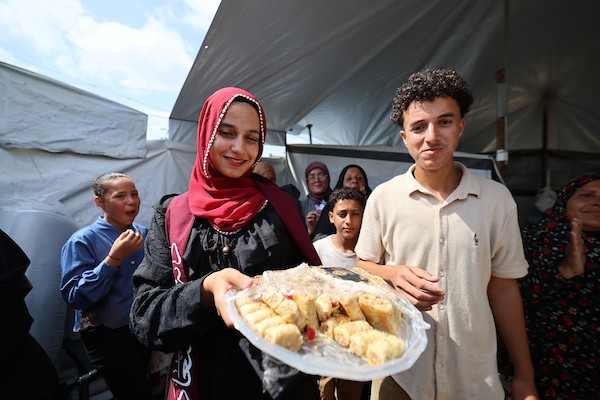 الطالبة دانا سعادة تحتفل مع عائلتها داخل خيمة للنازحين غرب مدينة غزة، بعد حصولها على معدل 96% في الفرع الأدبي بامتحانات التوجيهي، 24 تموز/ يوليو 2026. تصوير: بلال أسامة