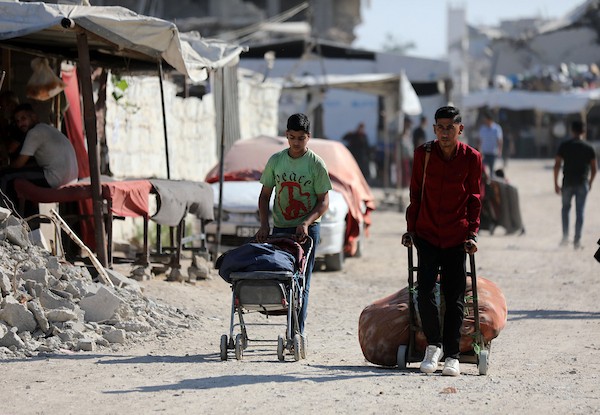 يحمل فلسطينيون نازحون أمتعتهم أثناء مغادرتهم خيامهم في حي الزيتون بمدينة غزة في 18 يوليو/تموز 2026. صورة: بلال أسامة