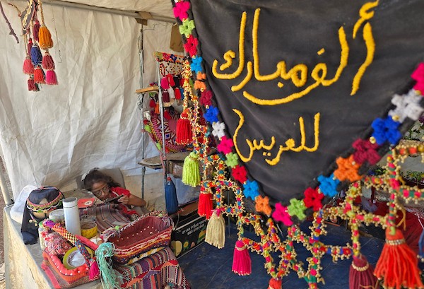 الفلسطينية النازحة شيرين نصار تجهّز مستلزمات الزفاف داخل خيمتها في منطقة المواصي، غربي خان يونس، في 22 يوليو/تموز 2026. تصوير: طارق محمد