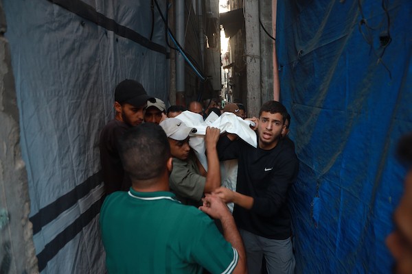 يحمل المشيعون جثامين فلسطينيين خلال جنازتهم في قطاع غزة في 18 يوليو/تموز 2026، بعد غارة جوية إسرائيلية استهدفت منزلاً، ما أسفر عن استشهاد خمسة مدنيين، بينهم طفل، وإصابة آخرين. صورة: عمر أشتوي