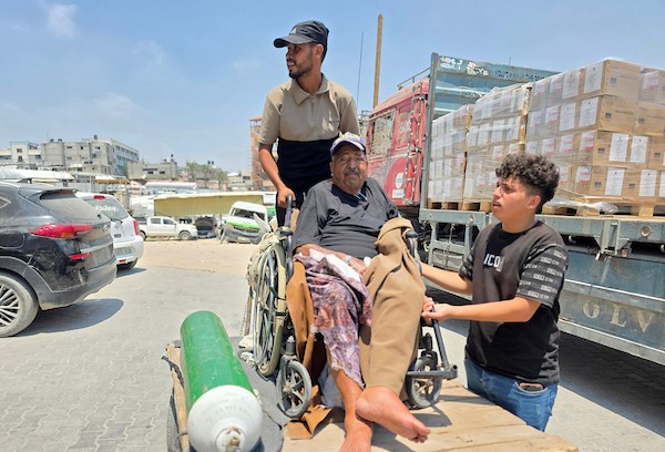 فتحي حجي، 77 عاماً، مريض كلى ويستخدم أسطوانة أكسجين، يجلس على كرسي متحرك أثناء نقله على عربة تجرها الحيوانات من منطقة بئر 19 في المواصي بمدينة خان يونس، جنوب قطاع غزة، في 22 يوليو/تموز 2026.  تصوير: طارق محمد