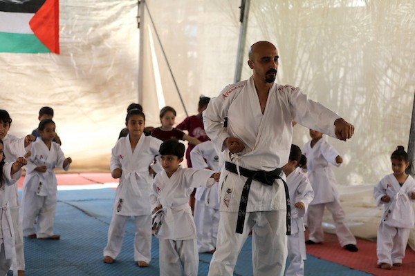 أطفال يتدربون على رياضة الكاراتيه داخل خيمة أقامها المدرب خليل عياد في دير البلح وسط قطاع غزة، في 6 تموز/يوليو 2026.تصوير: بلال أسامة