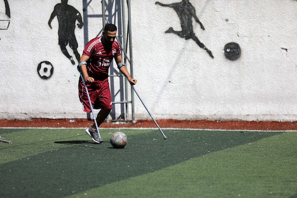 مبتورو الأطراف في غزة يعودون إلى الملعب برسالة صمود واندماج  شارك لاعبون فلسطينيون من مبتوري الأطراف، أصيبوا خلال الحرب في قطاع غزة، في مباراة رمزية أُقيمت على ملعب فلسطين بمدينة غزة، يوم 28 يوليو/تموز 2026، في مبادرة جمعت بين الرياضة والدعم الإنساني.  ونُظمت المباراة بالتعاون مع مؤسسة «دنيز فنيري»، بهدف دعم الرياضيين من مبتوري الأطراف وتعزيز دمج الأشخاص ذوي الإعاقة في المجتمع من خلال الرياضة، في ظل الظروف الصعبة التي يعيشها سكان القطاع.  وحملت عودة اللاعبين إلى أرض الملعب دلالة تتجاوز المنافسة الرياضية، إذ عكست تمسكهم بالحياة وقدرتهم على تجاوز آثار الإصابة واستعادة مساحة من النشاط والأمل، رغم التحديات الجسدية والنفسية التي خلّفتها الحرب.  وسعت المبادرة إلى تسليط الضوء على احتياجات المصابين من ذوي الإعاقة، وفتح المجال أمامهم لمواصلة ممارسة الرياضة والمشاركة الفاعلة في المجتمع.  تعليق الصورة: لاعبون فلسطينيون من مبتوري الأطراف يشاركون في مباراة رمزية على ملعب فلسطين بمدينة غزة، 28 يوليو/تموز 2026. تصوير: بلال أسامة.