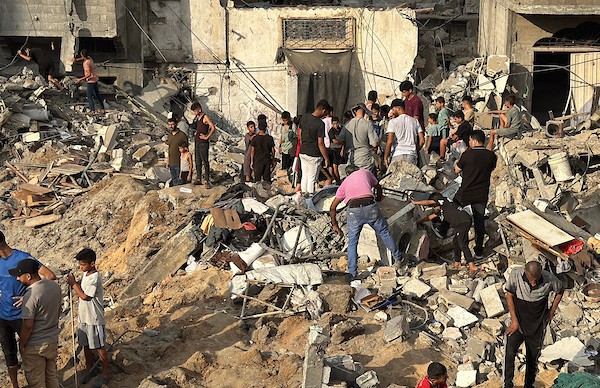 يتفقد فلسطينيون المباني المدمرة في موقع غارة جوية إسرائيلية على مخيم المغازي للاجئين، وسط قطاع غزة، يوم الجمعة 24 يوليو/تموز 2026. تصوير: أحمد إبراهيم