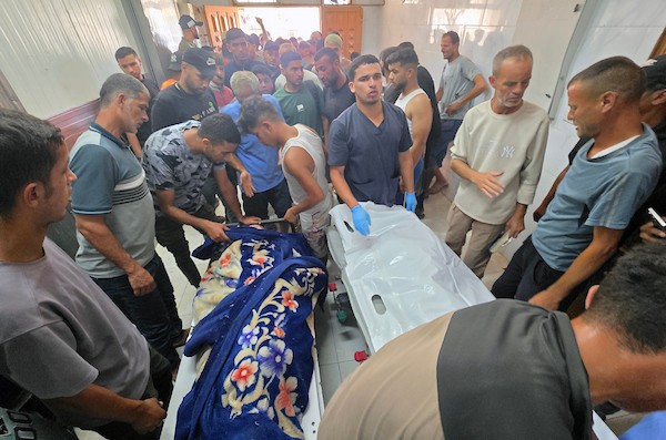 فلسطينيون ينقلون جثامين أربعة قتلى وعددًا من الجرحى، معظمهم من الأطفال، إلى مجمع ناصر الطبي في خان يونس جنوب قطاع غزة، في 8 يوليو/تموز 2026، بعد غارة إسرائيلية بطائرة مسيّرة استهدفت خيمة للنازحين جنوب المدينة، وفق مسعفين. تصوير: طارق محمد