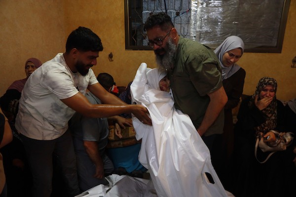 يحمل المشيعون جثامين فلسطينيين خلال جنازتهم في قطاع غزة في 18 يوليو/تموز 2026، بعد غارة جوية إسرائيلية استهدفت منزلاً، ما أسفر عن استشهاد خمسة مدنيين، بينهم طفل، وإصابة آخرين. صورة: عمر أشتوي