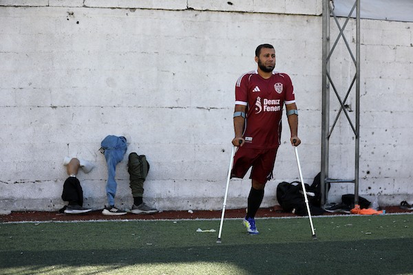 مبتورو الأطراف في غزة يعودون إلى الملعب برسالة صمود واندماج  شارك لاعبون فلسطينيون من مبتوري الأطراف، أصيبوا خلال الحرب في قطاع غزة، في مباراة رمزية أُقيمت على ملعب فلسطين بمدينة غزة، يوم 28 يوليو/تموز 2026، في مبادرة جمعت بين الرياضة والدعم الإنساني.  ونُظمت المباراة بالتعاون مع مؤسسة «دنيز فنيري»، بهدف دعم الرياضيين من مبتوري الأطراف وتعزيز دمج الأشخاص ذوي الإعاقة في المجتمع من خلال الرياضة، في ظل الظروف الصعبة التي يعيشها سكان القطاع.  وحملت عودة اللاعبين إلى أرض الملعب دلالة تتجاوز المنافسة الرياضية، إذ عكست تمسكهم بالحياة وقدرتهم على تجاوز آثار الإصابة واستعادة مساحة من النشاط والأمل، رغم التحديات الجسدية والنفسية التي خلّفتها الحرب.  وسعت المبادرة إلى تسليط الضوء على احتياجات المصابين من ذوي الإعاقة، وفتح المجال أمامهم لمواصلة ممارسة الرياضة والمشاركة الفاعلة في المجتمع.  تعليق الصورة: لاعبون فلسطينيون من مبتوري الأطراف يشاركون في مباراة رمزية على ملعب فلسطين بمدينة غزة، 28 يوليو/تموز 2026. تصوير: بلال أسامة.