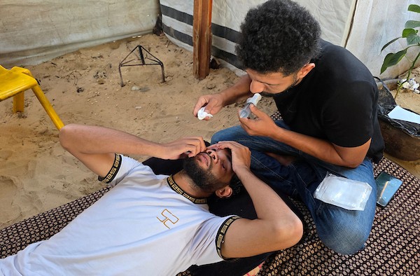 الشقيقان محمد دبور وموسى دبور داخل خيمة للنازحين في خان يونس، جنوب قطاع غزة، في 9 يوليو/تموز 2026. فقد محمد بصره بالكامل، فيما فقد موسى عينه اليسرى، إثر حادثة قرب مركز لتوزيع المساعدات في يوليو/تموز 2025 أودت بحياة شقيقهما حسين.(تصوير: طارق محمد)