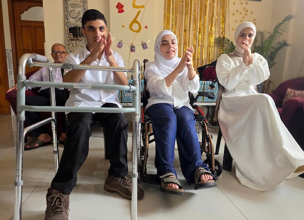 التوائم الفلسطينيون عبد الله وندى وسما موسى يحتفلون بنتائجهم المتميزة في امتحانات التوجيهي بمدينة خان يونس، جنوب قطاع غزة، بعد تجاوزهم ظروف الحرب والنزوح والإعاقة، 24 تموز/ يوليو 2026. تصوير: طارق محمد