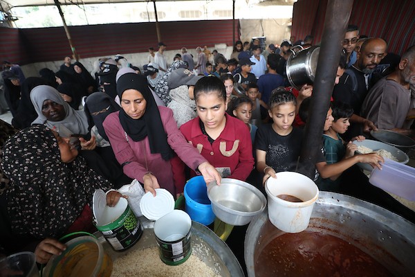 فلسطينيون نازحون يتجمعون للحصول على وجبات محدودة من مطبخ خيري يُعد الوحيد المتبقي في مخيم النصيرات وسط قطاع غزة، في 23 يوليو/تموز 2026. تصوير: حسن الجدي