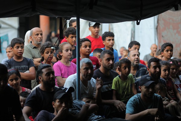 يشاهد فلسطينيون مباراة كرة قدم بين منتخبي مصر والأرجنتين داخل خيمة في مأوى تابع لوكالة (الأونروا) في مخيم النصيرات للاجئين، وسط قطاع غزة، في 7 يوليو/تموز 2026.(صورة حسن الجدي)