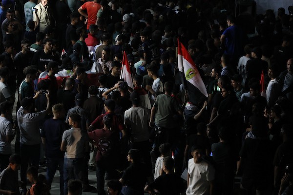 فلسطينيون يتابعون عبر شاشة عرض عامة في مدينة غزة مباراة مصر وأستراليا ضمن دور الـ32 من كأس العالم، في 3 يوليو/تموز 2026، وسط التحديات الإنسانية المستمرة في القطاع.  صورة: بلال أسامة