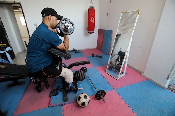 الرياضي الفلسطيني علام محمد شبير، 36 عامًا، لاعب كرة قدم سابق، يتدرب في صالة أنشأها داخل منزله المتضرر في مخيم الشاطئ للاجئين بمدينة غزة، في 22 يوليو/تموز 2026. صورة: بلال أسامة