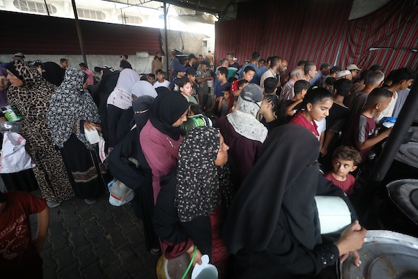 فلسطينيون نازحون يتجمعون للحصول على وجبات محدودة من مطبخ خيري يُعد الوحيد المتبقي في مخيم النصيرات وسط قطاع غزة، في 23 يوليو/تموز 2026. تصوير: حسن الجدي