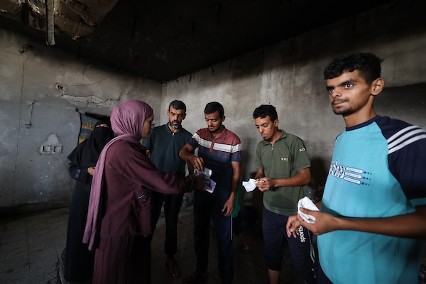 الطالبة رغد حجاج تحتفل مع عائلتها داخل الجامعة الإسلامية المتضررة في مدينة غزة، بعد حصولها على معدل 96% في المسار العلمي بامتحانات التوجيهي، عقب نزوح أسرتها من حي الشجاعية وتدمير منزلها خلال الحرب، 24 تموز/ يوليو 2026. تصوير: هادي داود