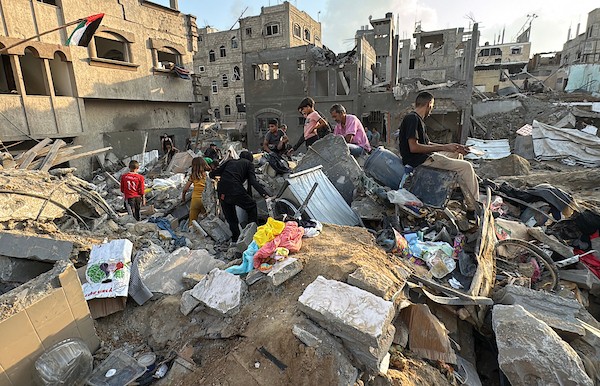 يتفقد فلسطينيون المباني المدمرة في موقع غارة جوية إسرائيلية على مخيم المغازي للاجئين، وسط قطاع غزة، يوم الجمعة 24 يوليو/تموز 2026. تصوير: أحمد إبراهيم