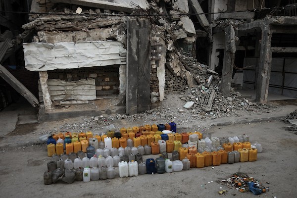 نازحون فلسطينيون يتجمعون للحصول على المياه من شاحنة توزيع في مخيم البريج وسط قطاع غزة، 8 يوليو/تموز 2026، مع تفاقم أزمة المياه إثر توقف عدد من محطات التحلية بسبب نقص الوقود. تصوير: معز صالحي