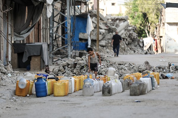 نازحون فلسطينيون يتجمعون للحصول على المياه من شاحنة توزيع في مخيم البريج وسط قطاع غزة، 8 يوليو/تموز 2026، مع تفاقم أزمة المياه إثر توقف عدد من محطات التحلية بسبب نقص الوقود. تصوير: معز صالحي