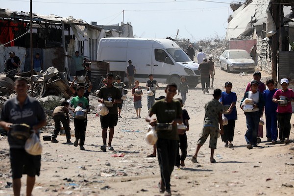 في الثاني من يوليو/تموز 2026، تجمع فلسطينيون نازحون، بينهم نساء وأطفال، لتلقي وجبات طعام من مركز توزيع خيري شرق مدينة غزة.صورة: بلال أسامة