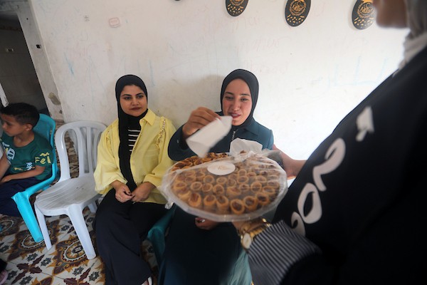 الطالبة نور سعيد عبد الدايم تحتفل مع عائلتها داخل منزلهم المتضرر في حي النصر بمدينة غزة، بعد حصولها على معدل 99.7% وحلولها ثانية على مستوى قطاع غزة في امتحانات التوجيهي، رغم فقدان والدها في غارة إسرائيلية سابقة، 24 تموز/ يوليو 2026. تصوير: بلال أسامة