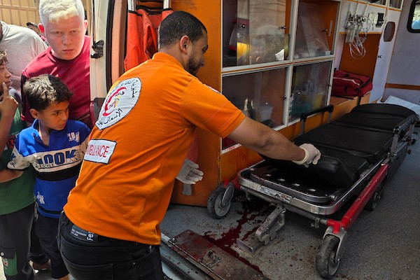 يحمل مسعفون جثتي شخصين بينما يتفقد آخرون موقع غارة إسرائيلية استهدفت تجمعًا فلسطينيًا في منطقة بطن السمين، جنوب خان يونس، 9 يوليو/تموز 2026. صورة: طارق محمد
